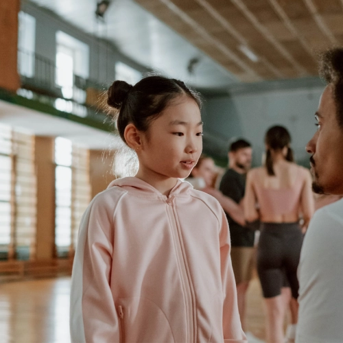 Young girl stood speaking to parent